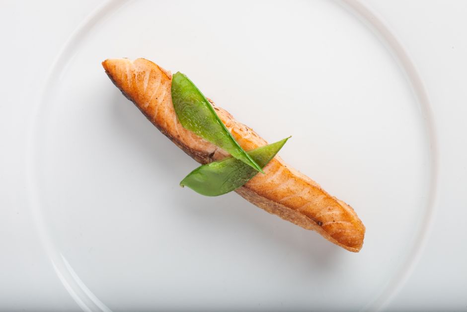 Air fryer salmon for one served as a single cooked fillet on a white plate.