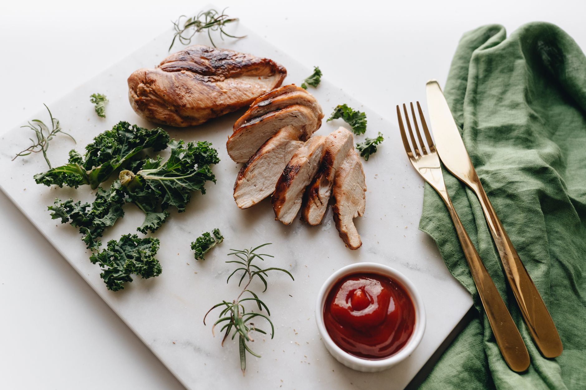 Air fryer chicken breast for one, sliced and served with greens.