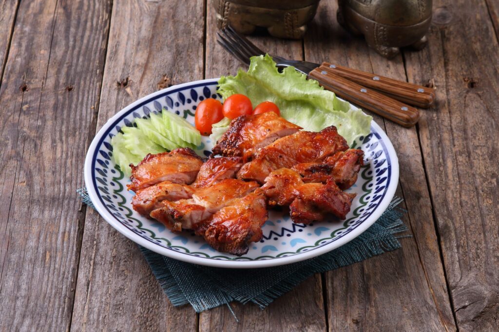 Air fryer chicken thighs for one sliced and served with fresh vegetables.