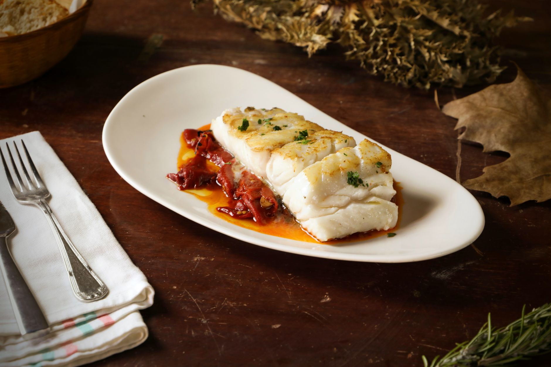Air fryer cod for one served as a flaky white fish fillet with red pepper.