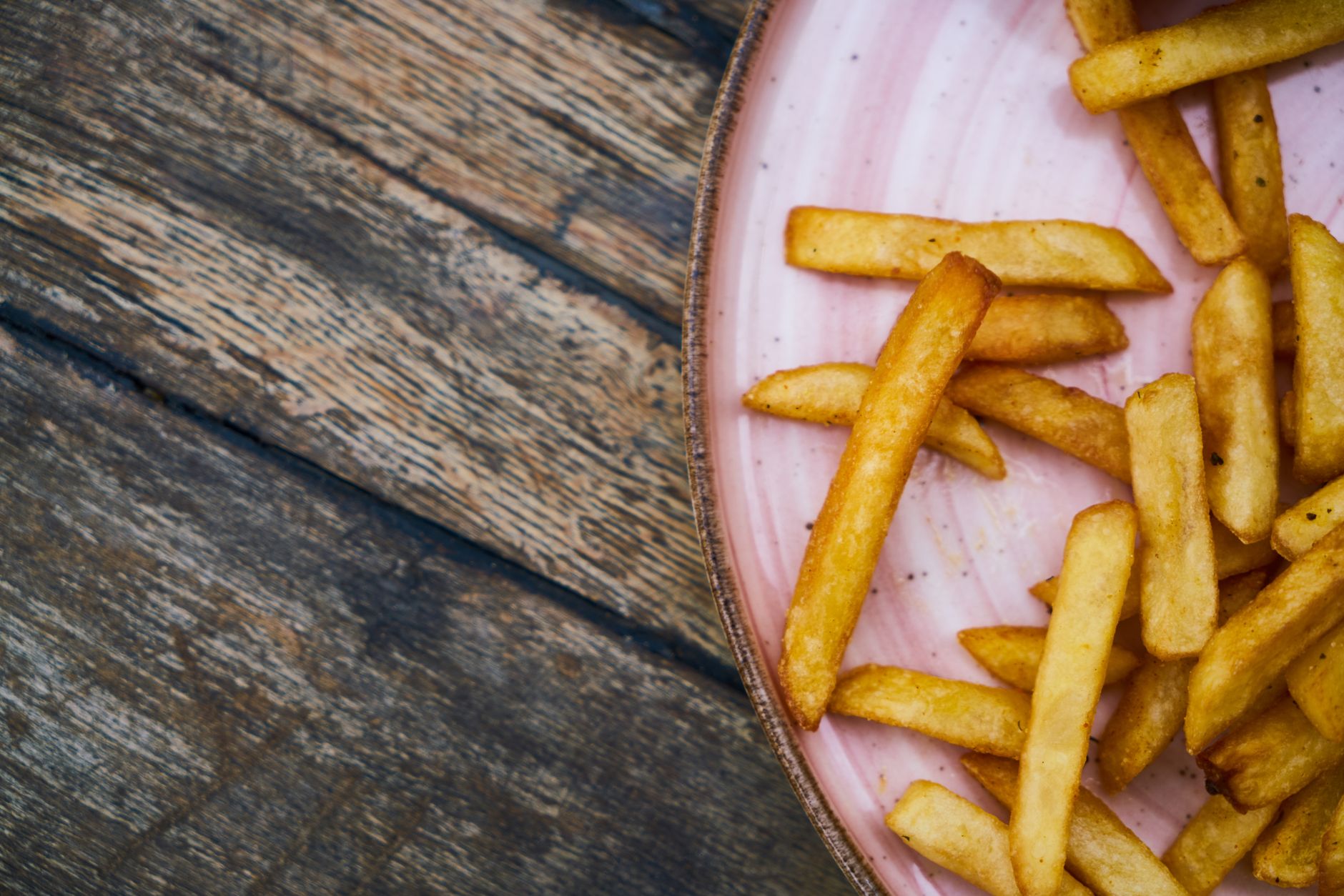 Air fryer French fries for one served golden on a pink ceramic plate.