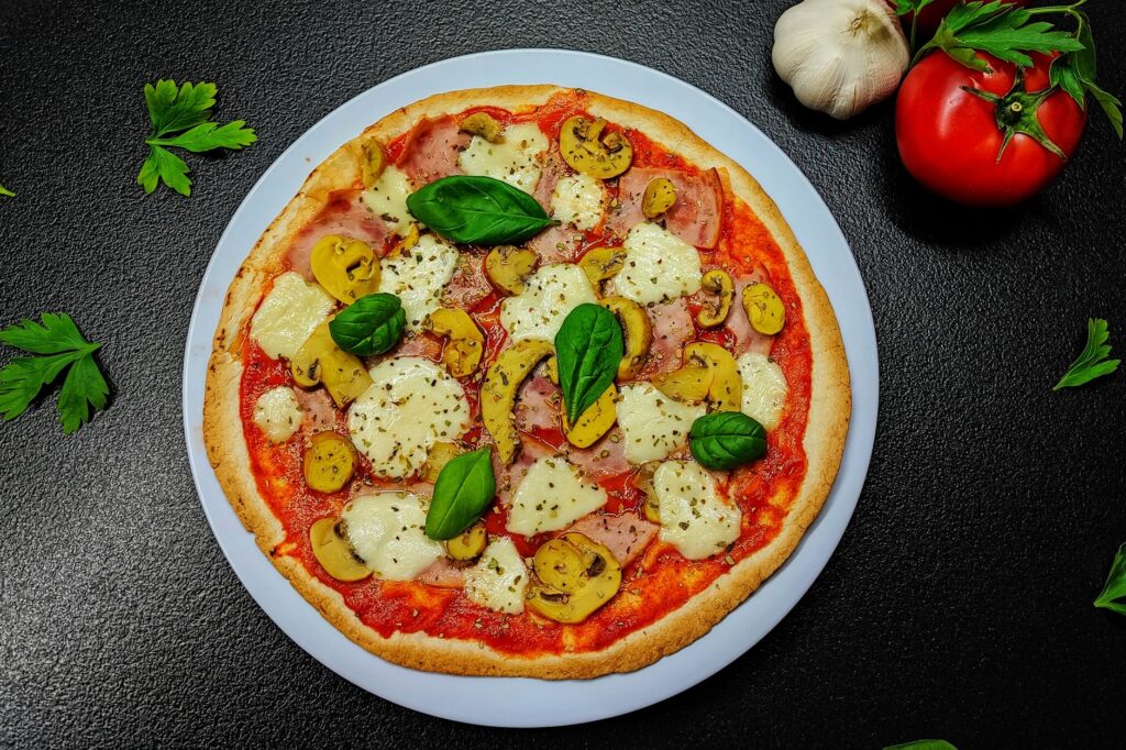 Crisp air fryer mini pizza for one topped with cheese, mushrooms, and fresh basil.