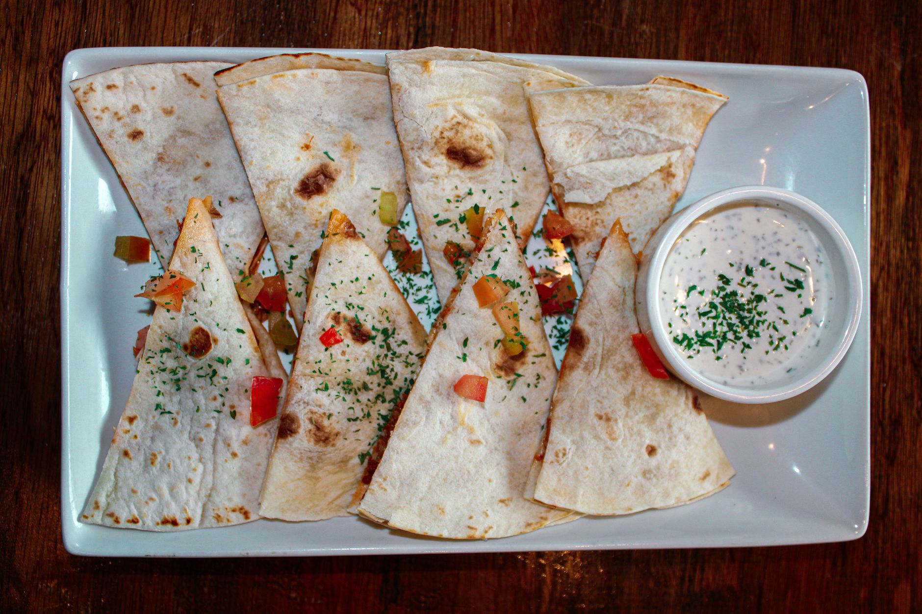 Air fryer quesadilla for one served with salsa and a creamy dip.