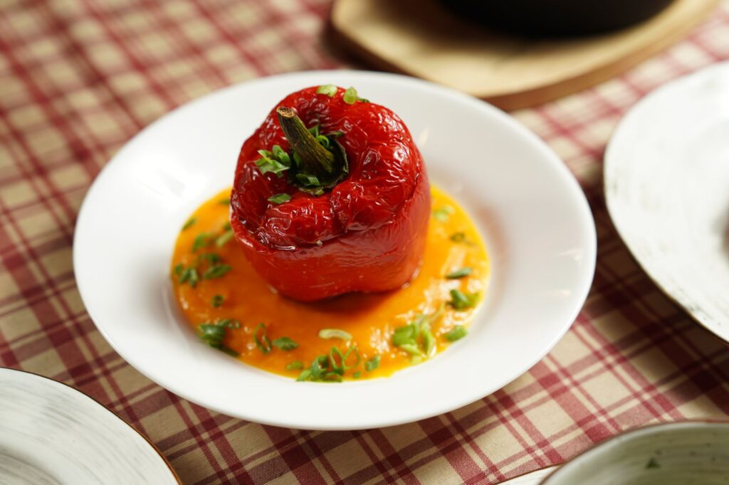 Air fryer stuffed pepper for one served as a single baked red bell pepper on a white plate.