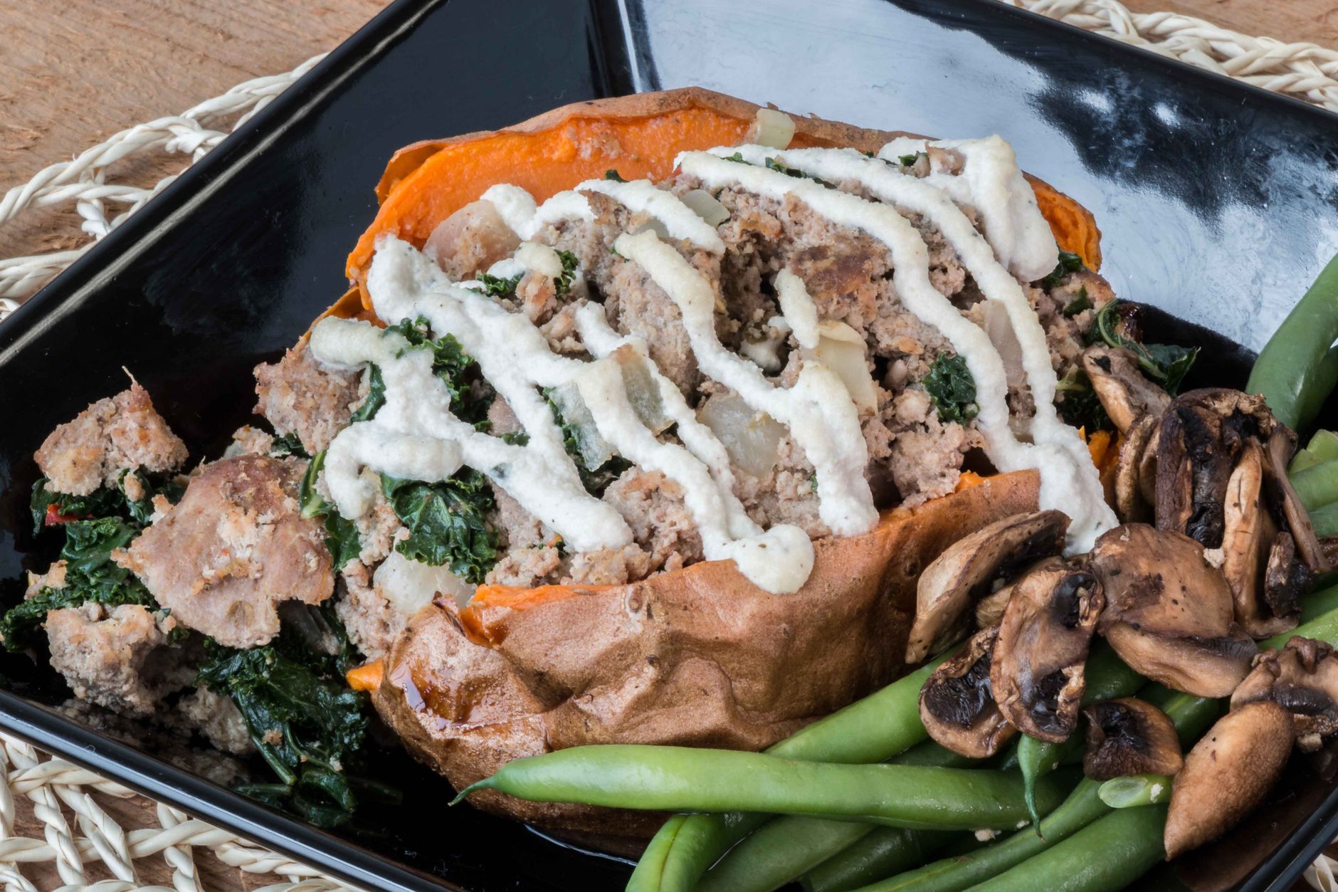 Air fryer sweet potato for one shown split open and loaded with savory toppings as a serving suggestion.