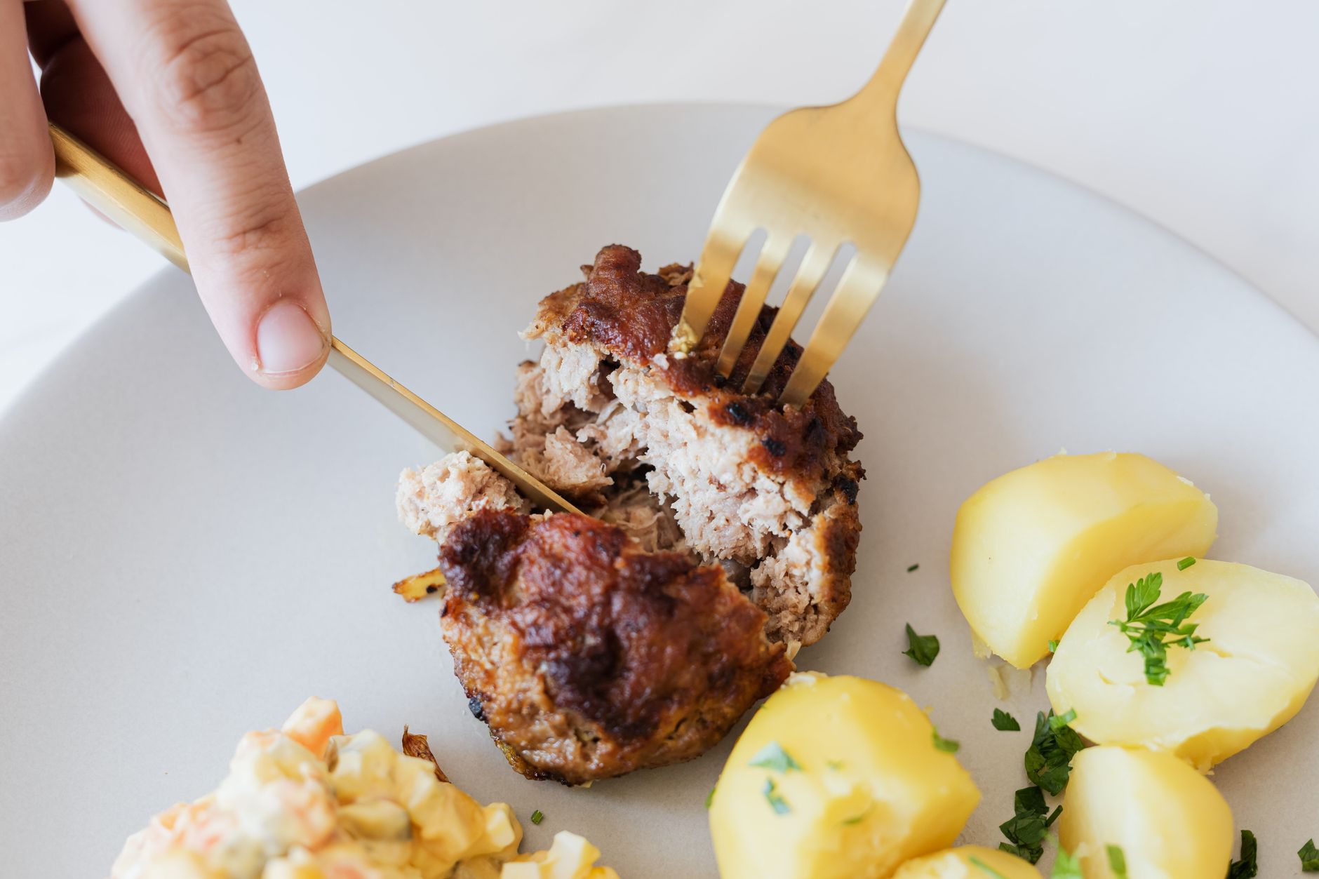 Serving suggestion for air fryer turkey meatloaf for one with a small browned ground-meat loaf and potatoes.