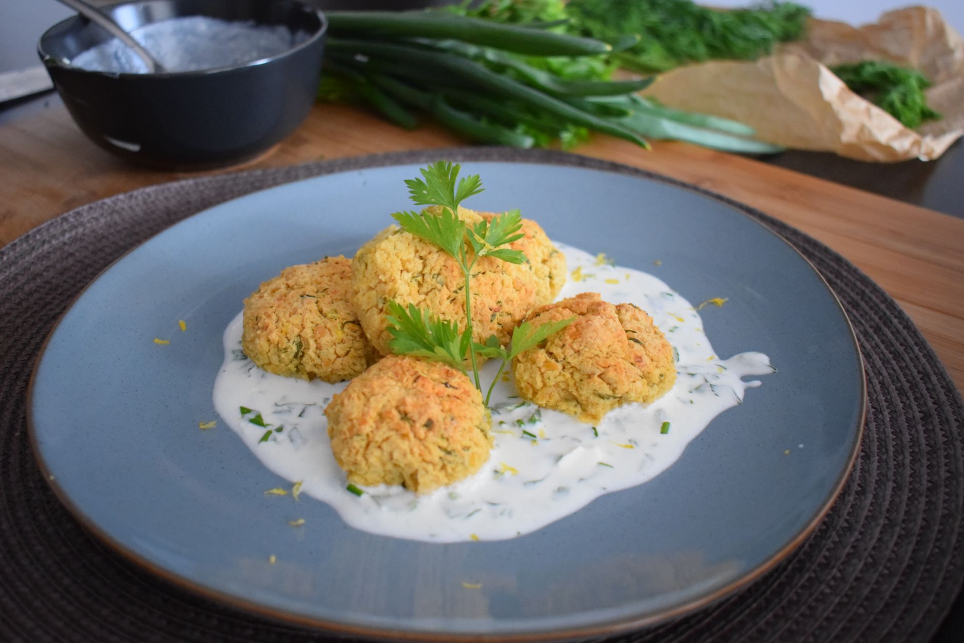 Serving suggestion for air fryer falafel for one: four chickpea patties with herbs and sauce.