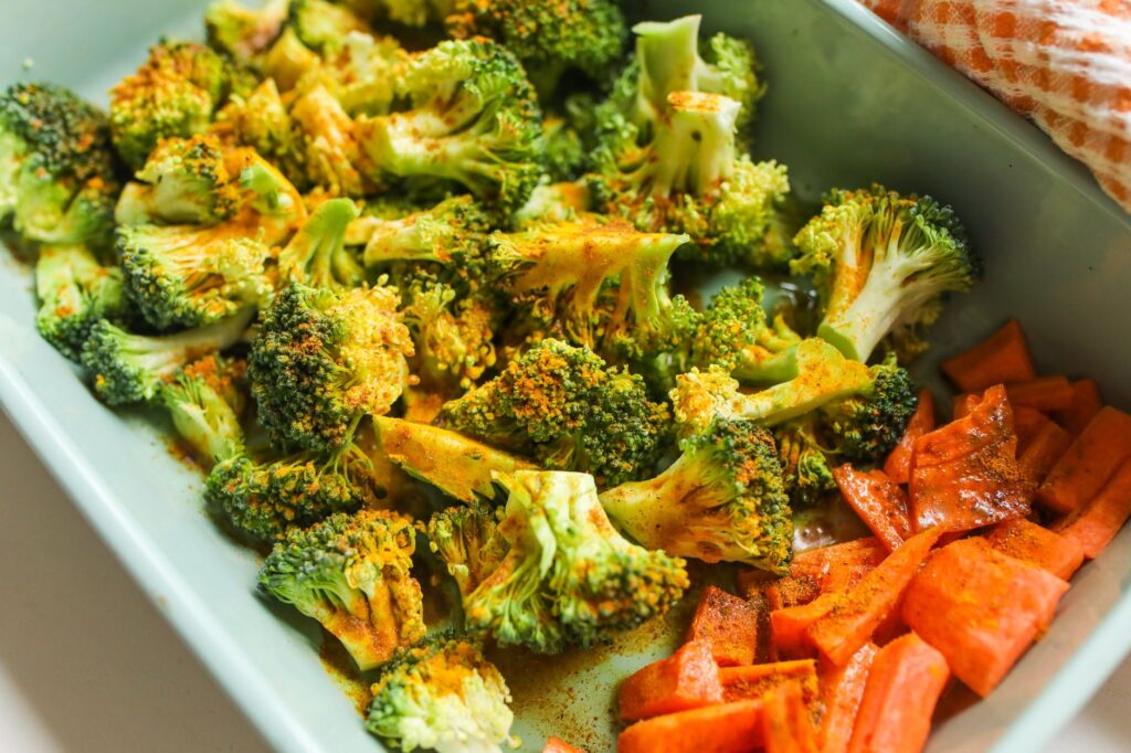 Air fryer broccoli for one prep inspiration: seasoned broccoli florets with carrots in a serving dish.