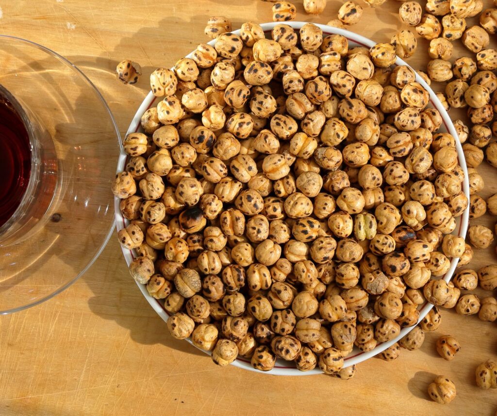 Serving inspiration for air fryer chickpeas for one: a larger bowl of roasted chickpeas on a wooden table.