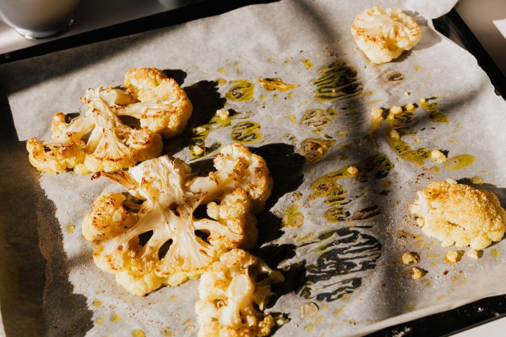 Serving inspiration for air fryer cauliflower for one: browned cauliflower on a tray, cut larger than the recipe florets.